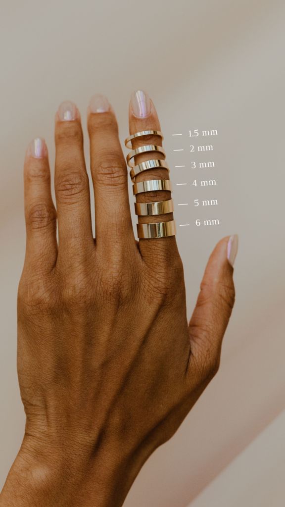 a woman's hand with five rings on her fingers and measurements for each ring