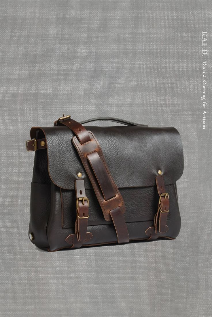 a brown and black leather briefcase on a gray background