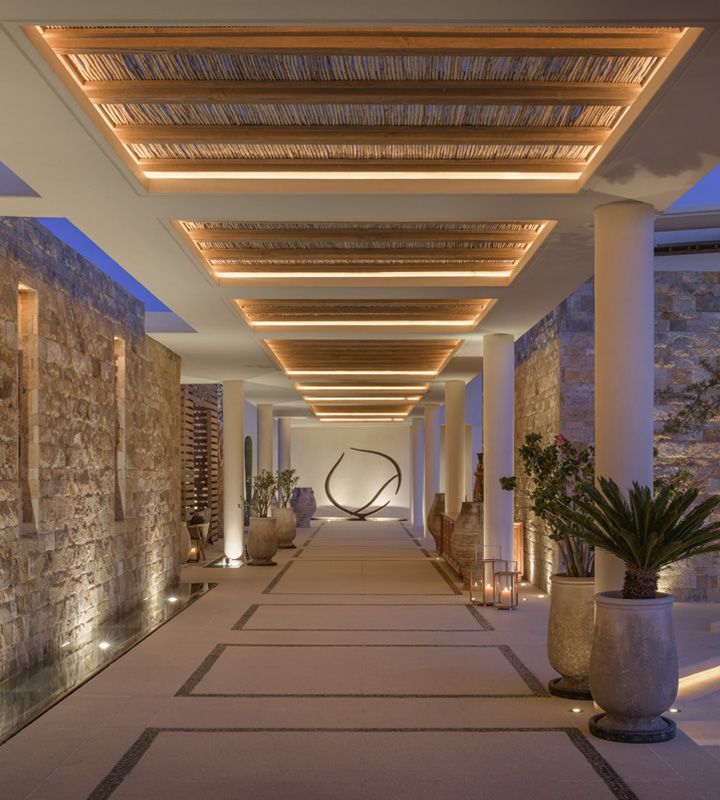 a long hallway with stone walls and lights on the ceiling is lit up at night