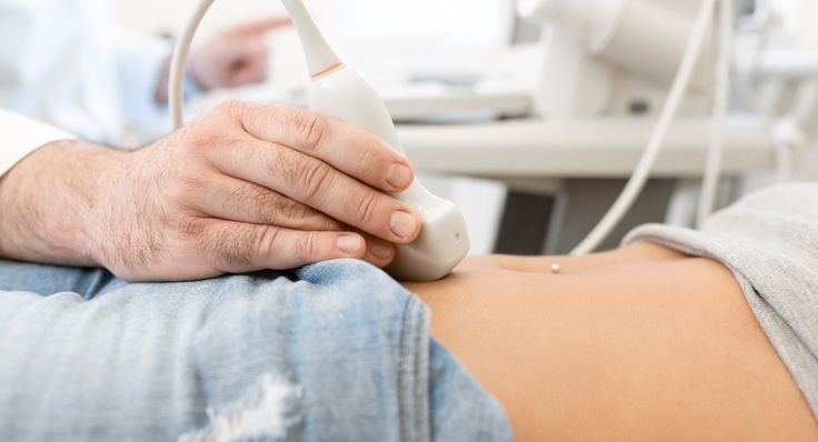 a person is holding the arm of another person in a hospital bed with an iv machine