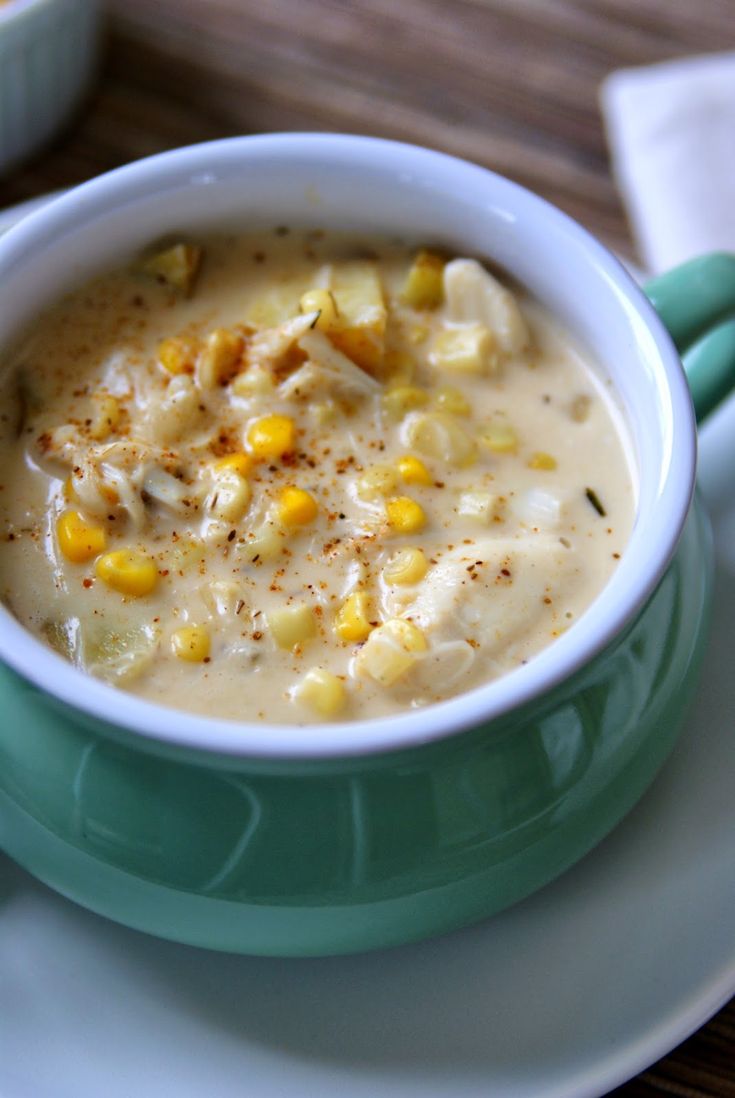 a green and white bowl filled with soup on top of a plate