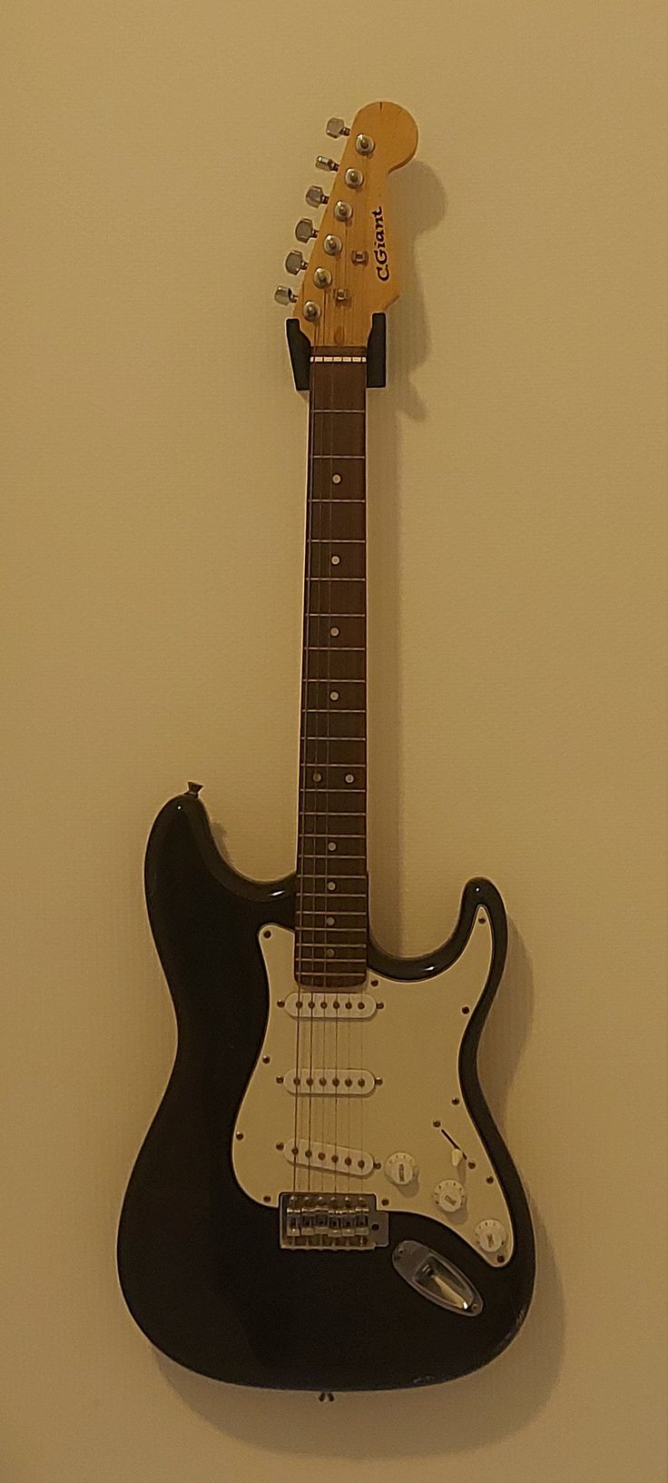 an electric guitar hanging on the wall