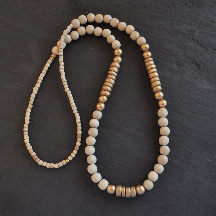 With a mix of whitewash and gold wood beads and in an easy pull-over-the-head style, this limited edition wood bead necklace is sure to dress up...well, anything! 8mm whitewashed and gold painted wooden beads gold-plated crimp with bead closure 28 inches long all Libby & Smee necklaces come packaged in a clear resealing bag for storage Gold Beaded Necklace With Wooden Beads, Elegant Gold Beaded Necklaces With Wooden Beads, Adjustable Gold Necklace With Wooden Beads, Vintage Gold Beaded Necklace With Wooden Beads, Wood Bead Necklace Gold, Wood Bead Necklace, Gold Wood, Gold Paint, Wooden Beads