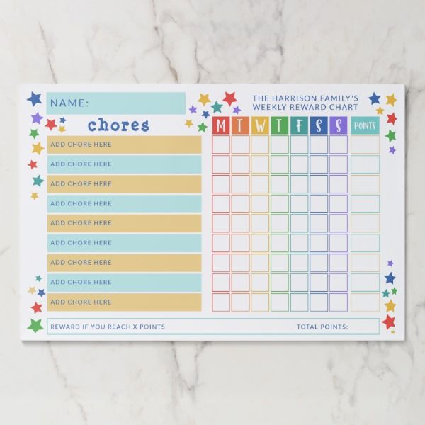 a printable chore chart on a marble counter top with colorful stars around it