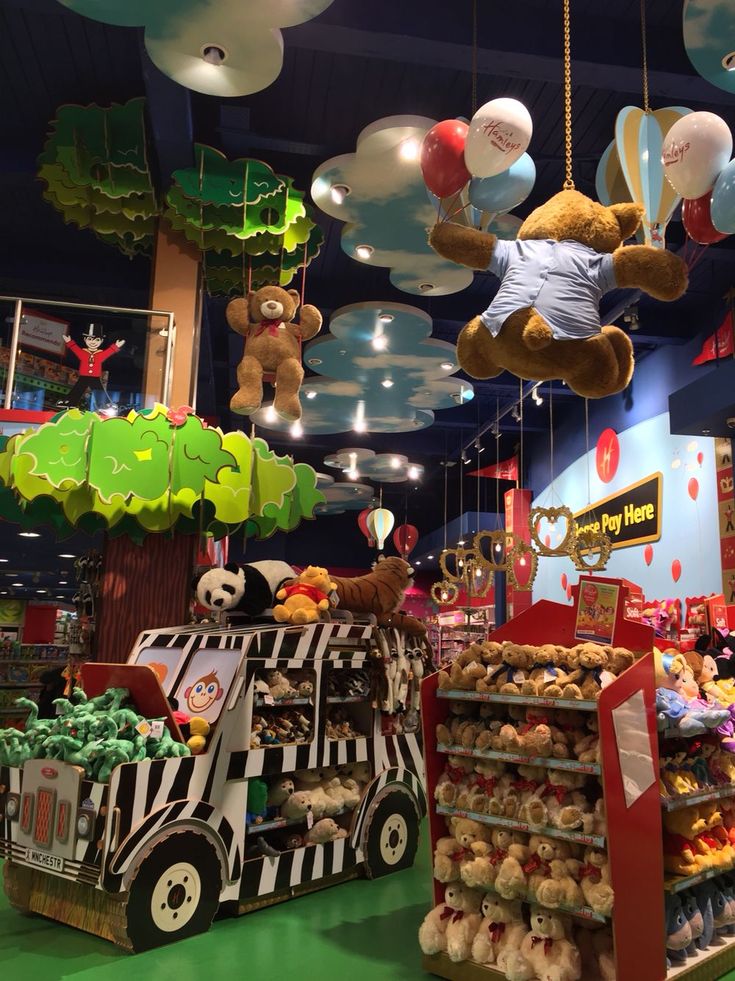 stuffed animals are hanging from the ceiling in a toy store