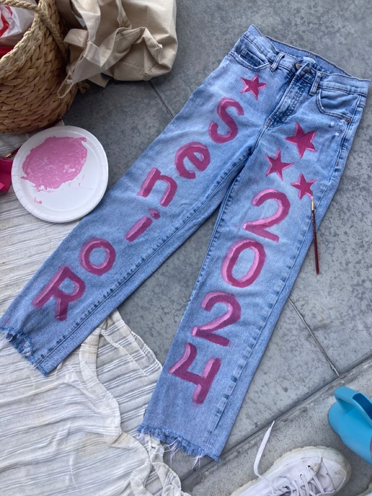 an old pair of jeans with the word rock on them and some shoes next to it