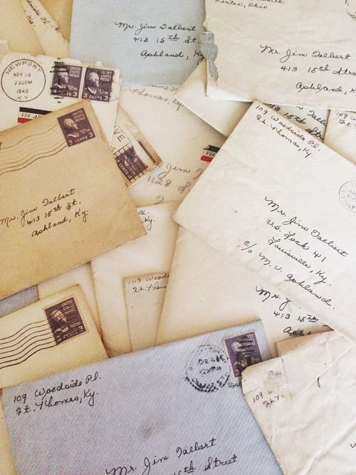 an assortment of old envelopes and letters are piled on top of each other,