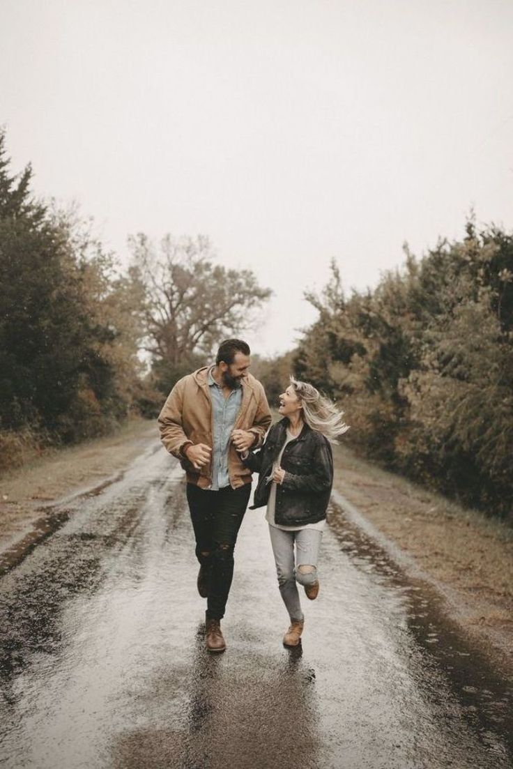 a man and woman walking down a wet road