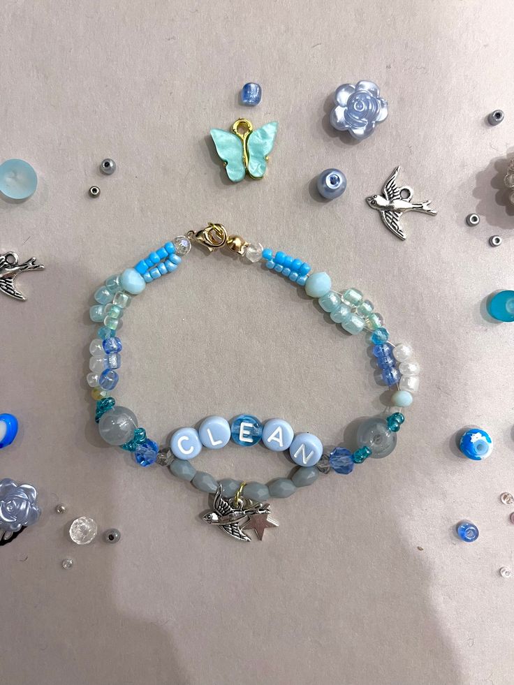 a bracelet with beads and charms on it next to other items that are scattered around