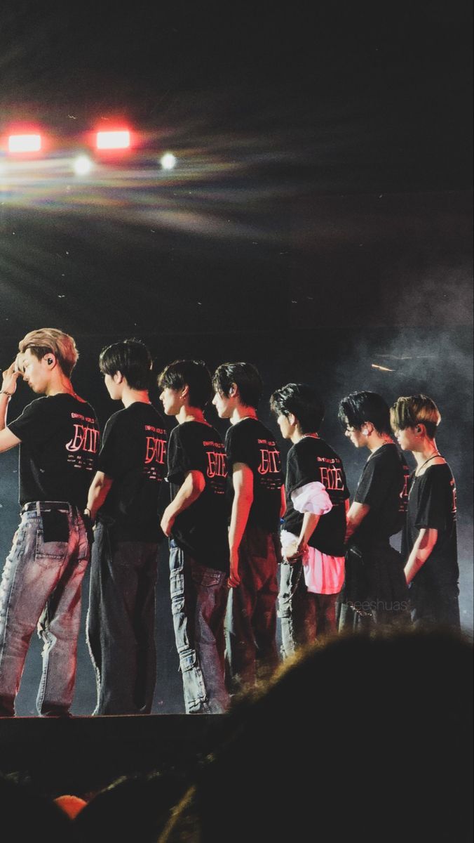 a group of young men standing next to each other on top of a stage in front of a crowd