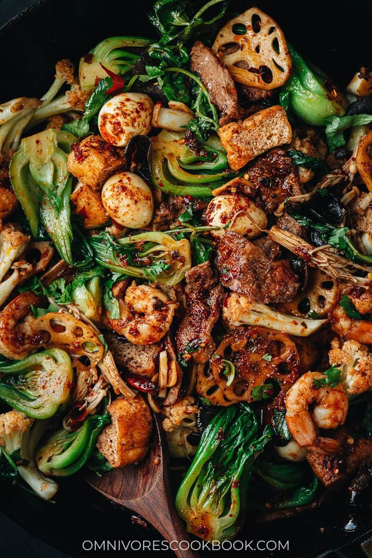 a skillet filled with stir fry vegetables and meat