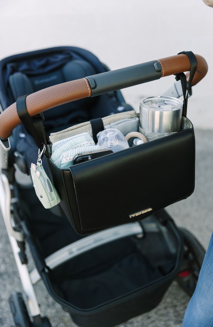 the baby stroller is full of drinks and cans in it's holder,