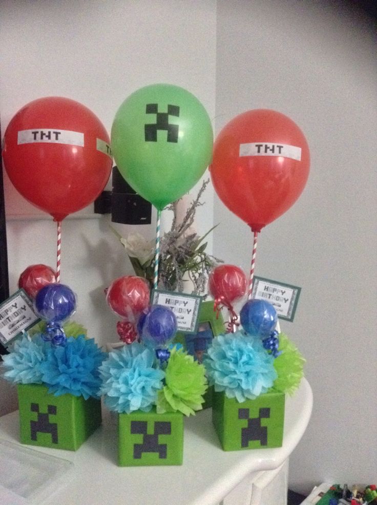 a table with balloons and gift boxes on it for minecraft themed birthday party decorations