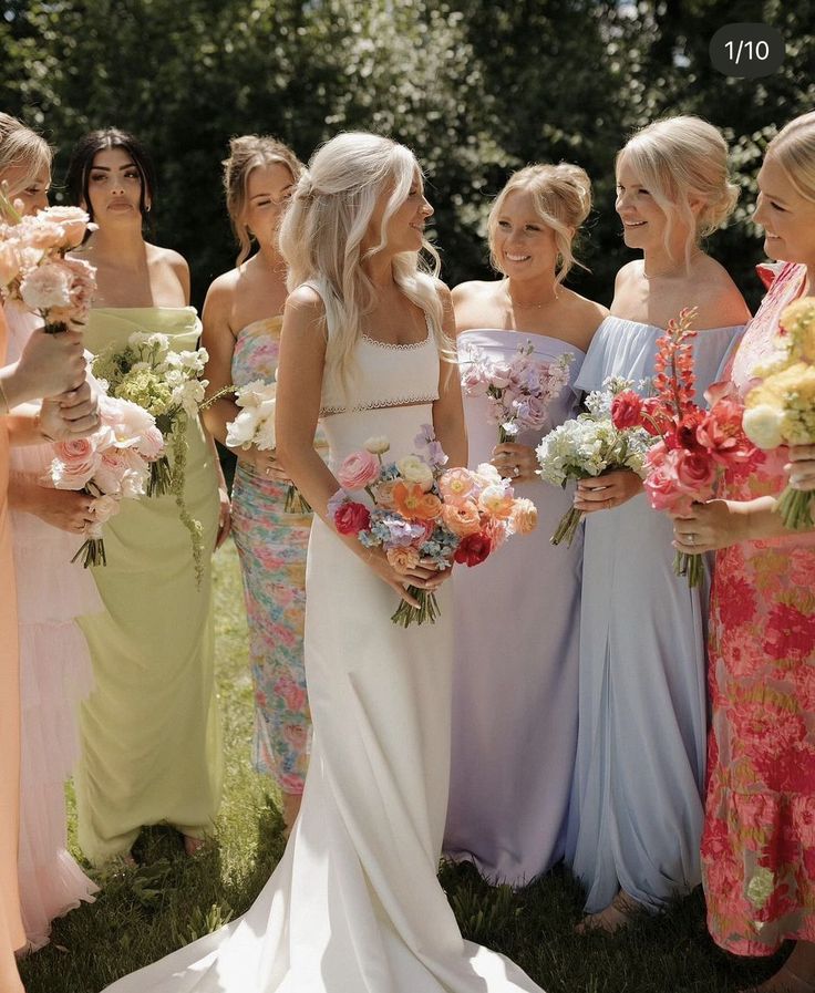 a group of women standing next to each other holding bouquets