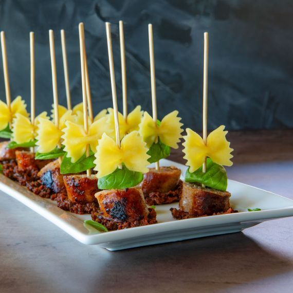 small appetizers are arranged on a plate with toothpicks in the shape of flowers