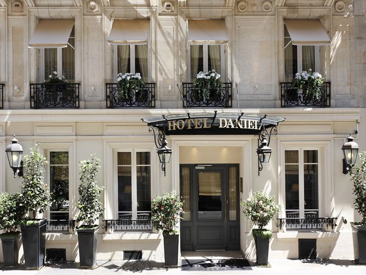 the hotel darnier in paris is decorated with flowers and potted plants on either side of the entrance