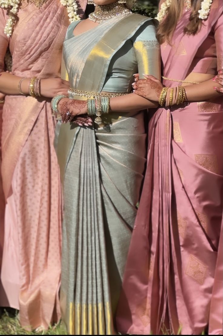 three women in sari standing next to each other