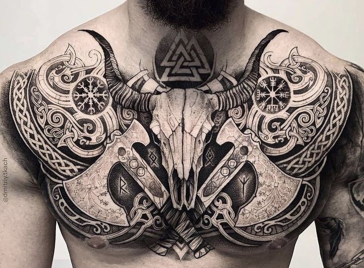 a man with tattoos on his chest has an animal skull in the middle of it