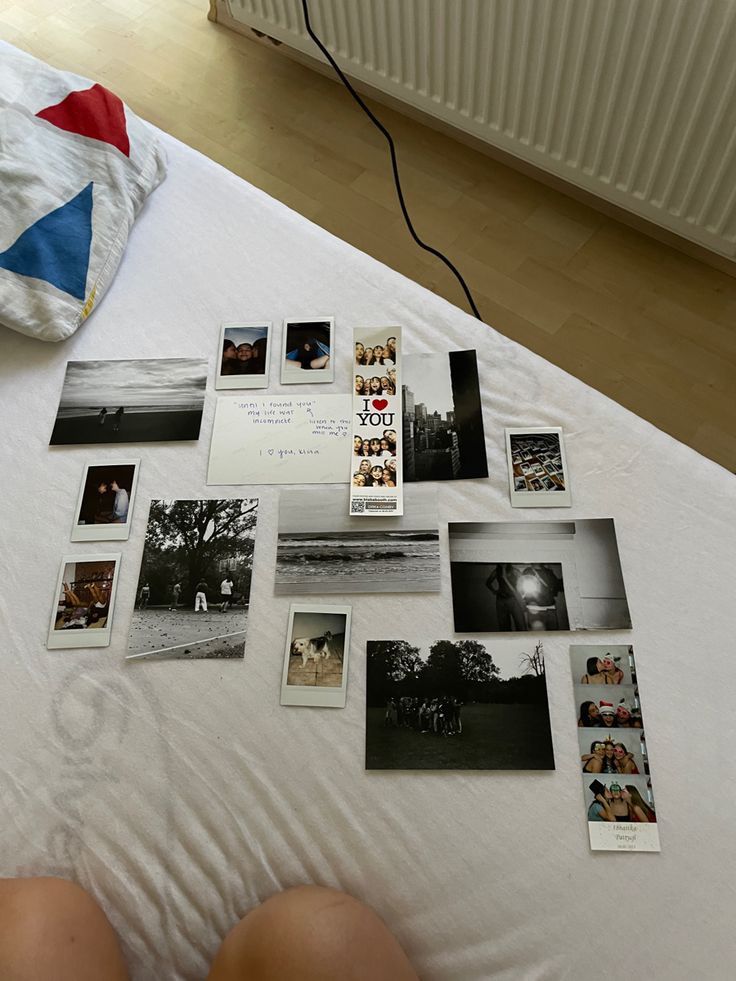 a person laying on top of a bed covered in pictures and magnets next to a heater