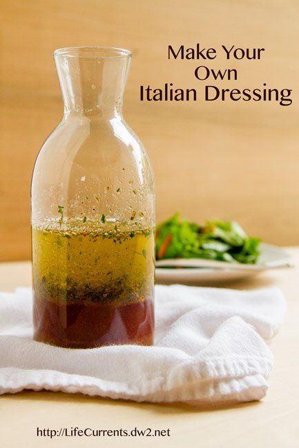 a bottle filled with olive oil sitting on top of a table next to a plate