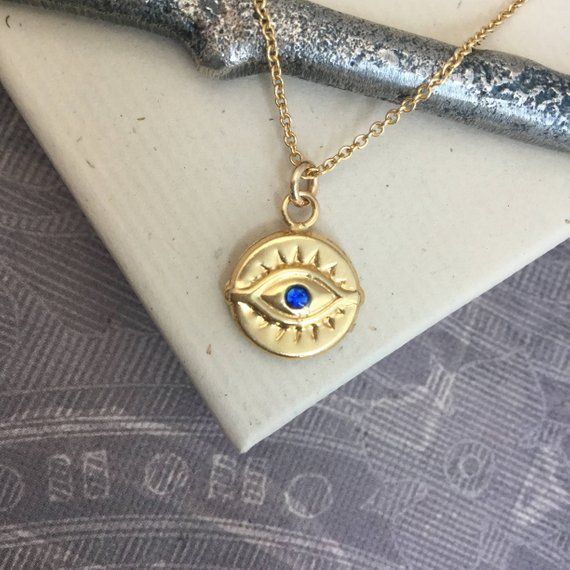 ⇩CLICK BELOW FOR DETAILS⇩Please note that I make every effort to mail your order within 24 hours of receipt. However, USPS is experiencing significant delivery delays and many packages are taking 2-3 weeks to arrive.Made of all 14kt gold filled, this beautiful evil eye necklace has a 11.5mm disc shaped evil eye charm with a tiny and bright faceted synthetic blue sapphire or red ruby center stone.  The charm is identical on both sides, and hangs a jump ring from a delicate 14kt gold filled chain, Luck Necklace, Good Luck Necklace, Protection Jewelry, Jewelry Card, Evil Eye Pendant, Disc Necklace, Evil Eye Charm, Evil Eye Necklace, Red Ruby