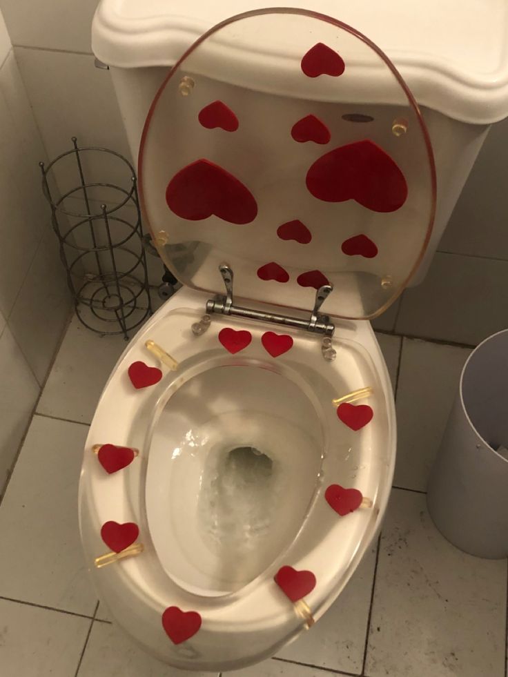 a white toilet with red hearts on it