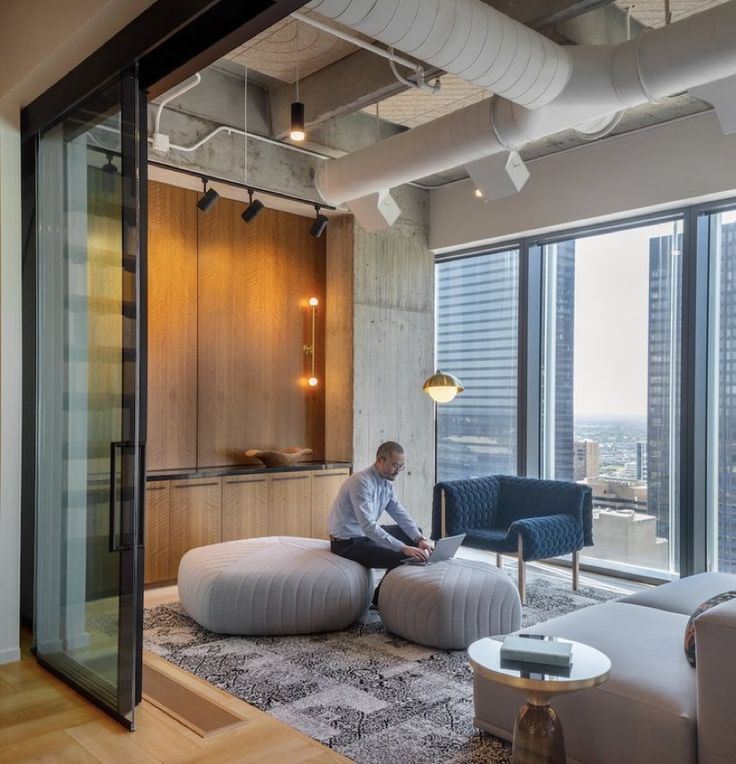 a man sitting on top of a bean bag chair in a living room next to a window