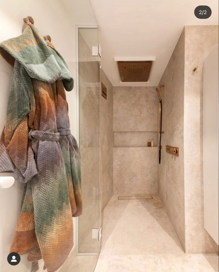 there is a robe hanging on the wall next to the shower in this bathroom,