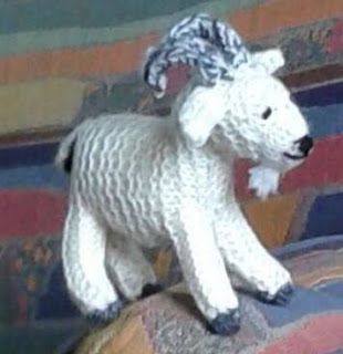 a white stuffed animal sitting on top of a couch