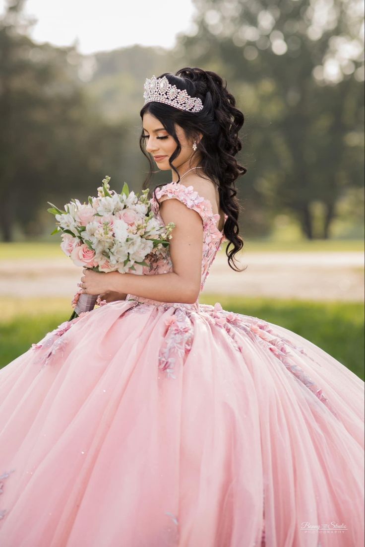 a woman in a pink dress holding flowers