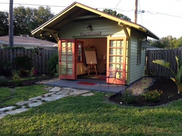 a small shed with an open door in the yard