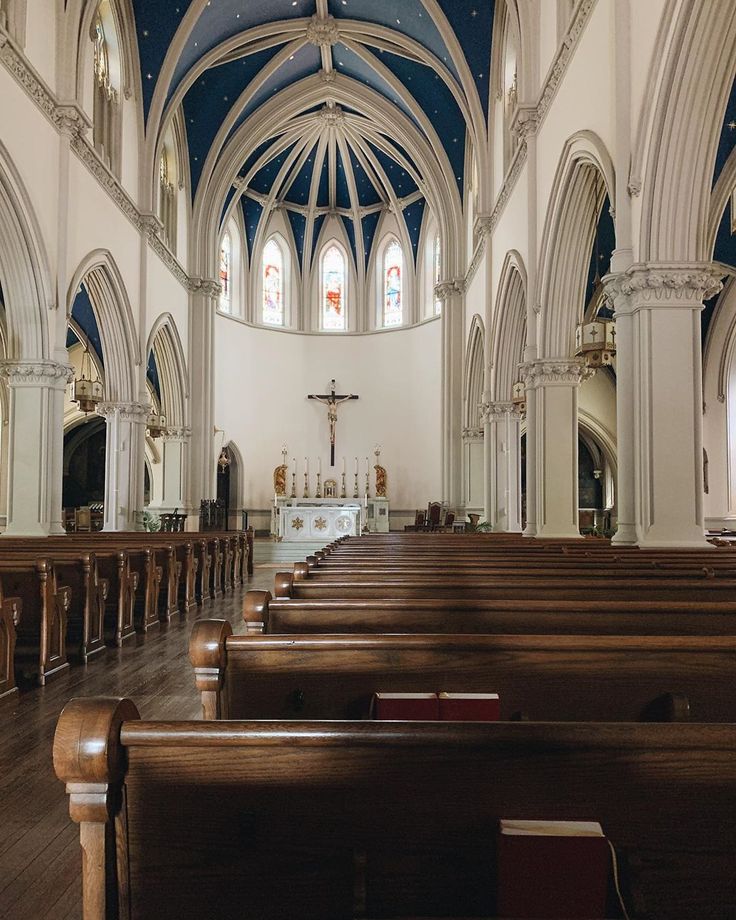 the inside of a church with pews and stained glass windows