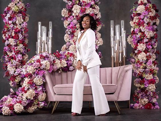 a woman standing in front of a floral display