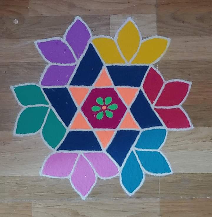 a colorful flower made out of colored paper on a wooden floor