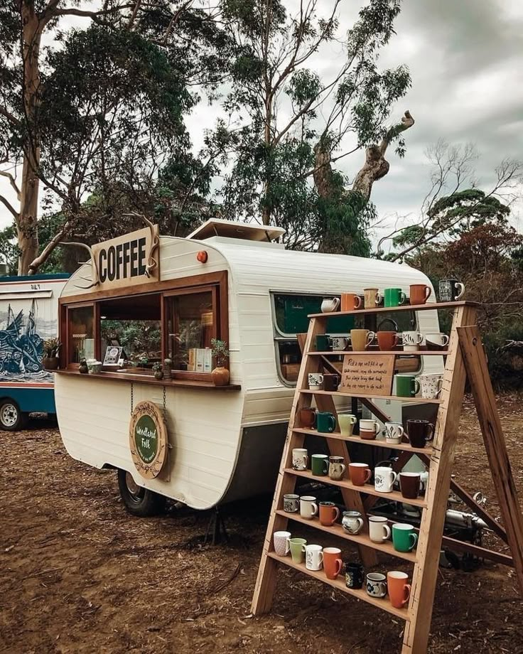 an old camper parked on the side of a dirt road next to a tree