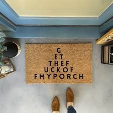 a person standing in front of a door mat that says get the f k off my porch