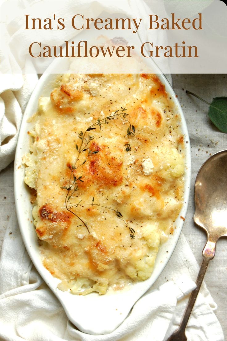 a white dish filled with macaroni and cheese on top of a table next to a spoon