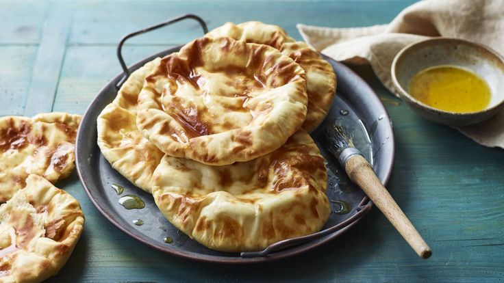 some pies are on a plate next to a bowl of oil