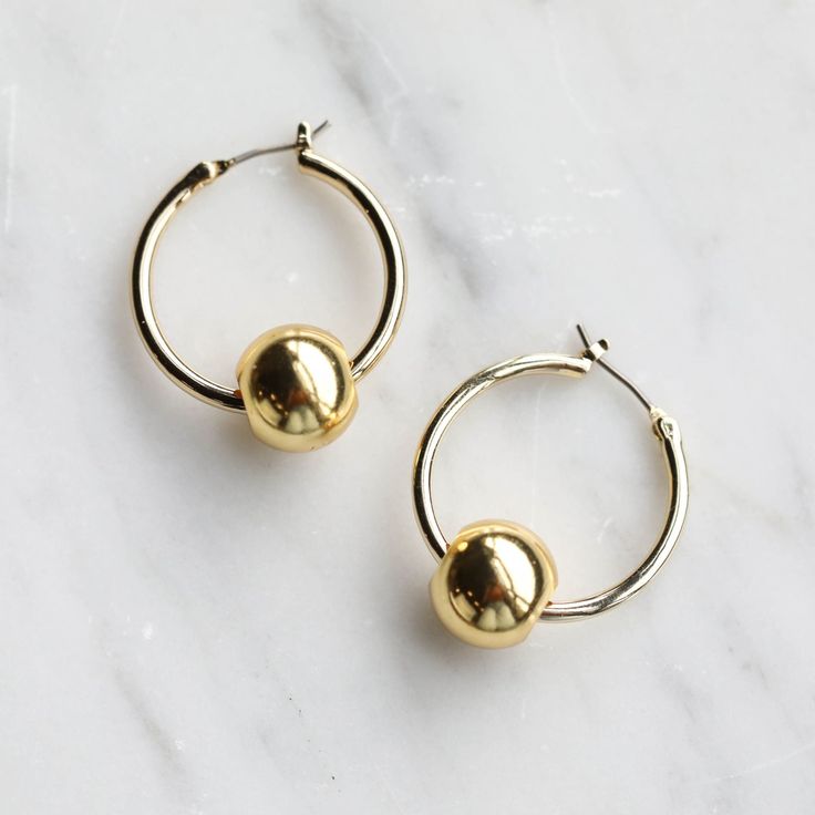 Discover endless possibilities with this set of two 14mm gold beads. These Roma Beads are classically sophisticated and the perfect addition to your pair of gold or silver Halo Hoops. *(Halo Hoops sold separately) Elegant Brass Jewelry With Polished Beads, Gold Earrings With Spacer And Round Beads, Modern Gold Jewelry With Polished Beads, Elegant Gold Earrings With Polished Beads, Gold Earrings With Polished Round Beads, Gold Earrings With Polished Beads For Gift, Gold Hoop Earrings With Spacer Beads As Gift, Gold Hoop Earrings With Spacer Beads, Gold Hoop Earrings With Spacer Beads For Gift