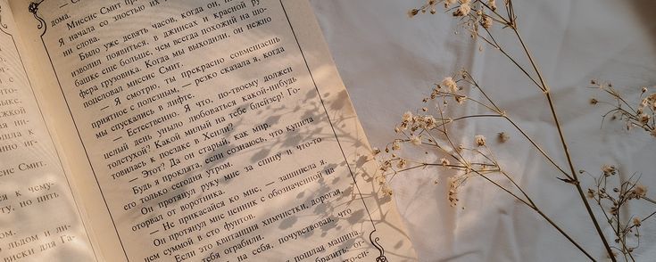 an open book sitting on top of a white sheet