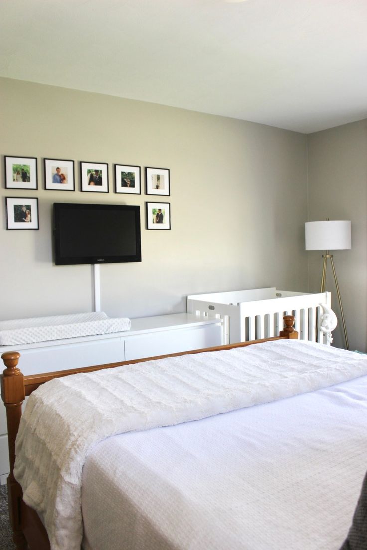 a bed with white sheets and pictures on the wall above it, in a bedroom