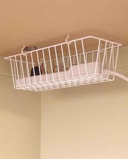 a white wire basket hanging from the ceiling