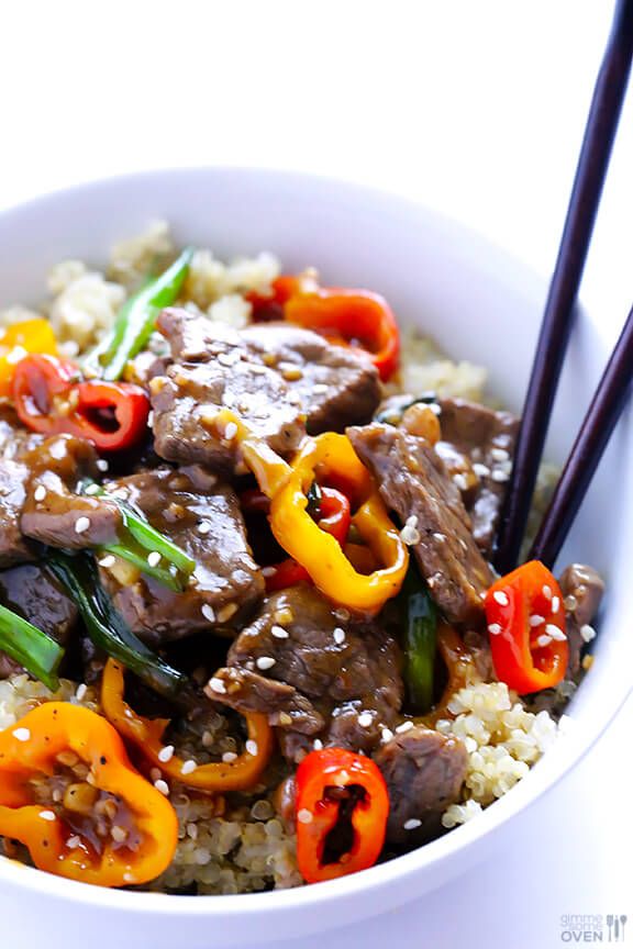 a white bowl filled with beef and peppers on top of couscouse rice