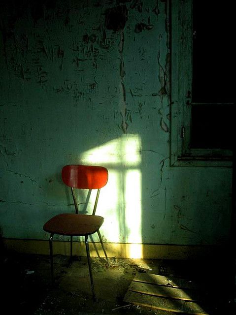 a red chair sitting in front of a window