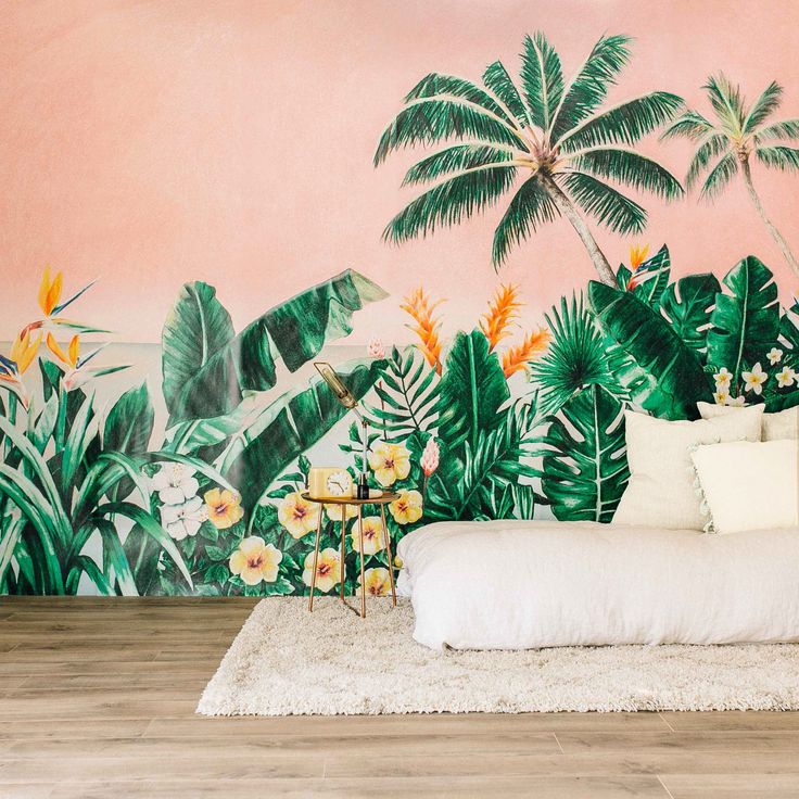 an image of a bed in front of a wall with tropical leaves and flowers on it