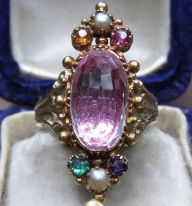 This beautiful Georgian ring is a real show stopper! Center stone is a genuine pink tourmaline set in 14k Yellow Gold with smaller paste stones surrounding it. Currently a size 7 but very easily sizable by any local jeweler. All questions are welcome! Thank you kindly. Pink Oval Multi-stone Ruby Ring, Pink Hallmarked Victorian Ruby Ring, Victorian Pink Hallmarked Ruby Ring, Pink Victorian Hallmarked Ruby Ring, Pink Oval Ruby Ring With Gemstone Accents, Formal Pink Multi-stone Sapphire Ring, Pink Oval Ring With Gemstone Accents, Pink Oval Victorian Jewelry, Pink Multi-stone Amethyst Ring