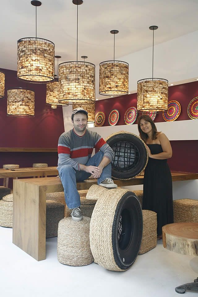 a man and woman sitting on top of large tires in a room with chandeliers