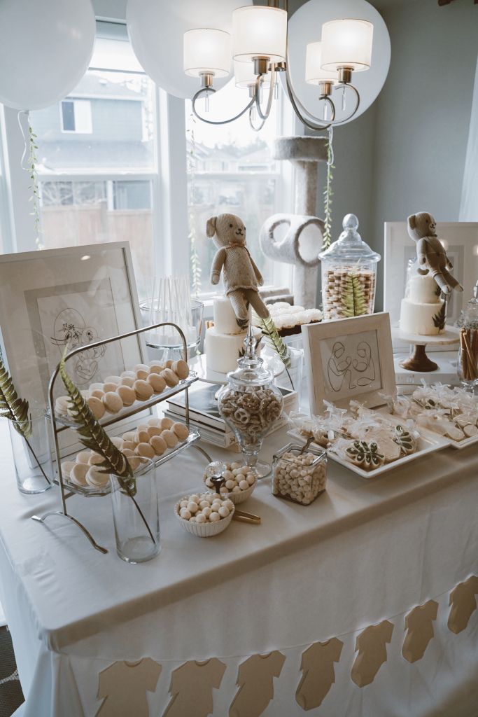 a table topped with lots of desserts and candies on top of a white table cloth