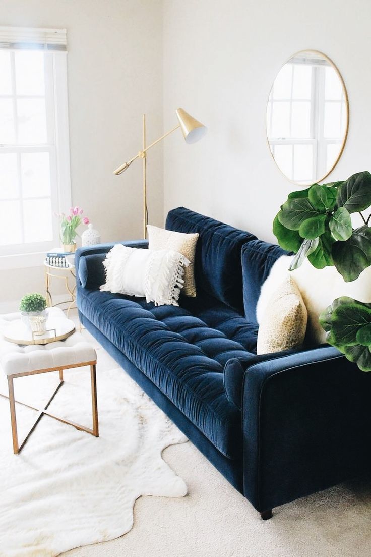 a living room with a blue couch and white rug