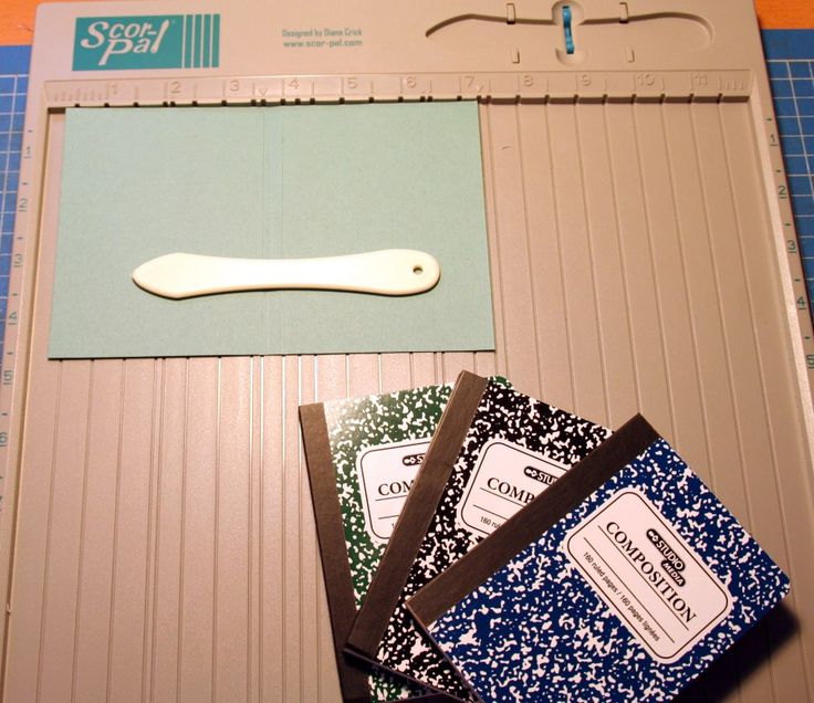 some scissors are laying on top of different types of fabric and papers in a box